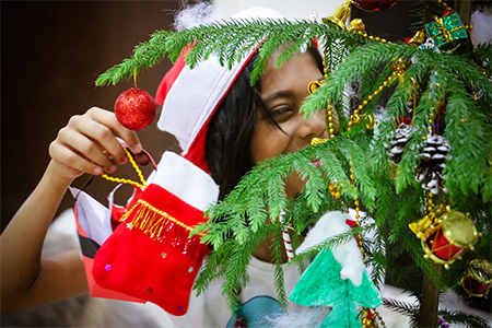 Little girl happy decorating the Christmas tree