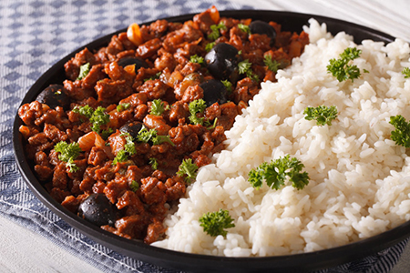 Picadillo a la habanera with a side dish of rice close-up on a plate