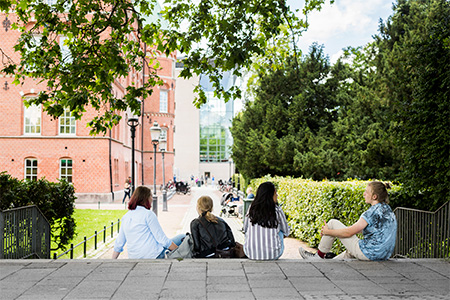 Students sitting on stairs outside university