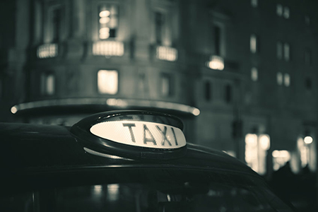 Vintage taxi in street in London at night.