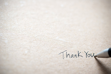 Hand writing thank you on piece of old grunge paper