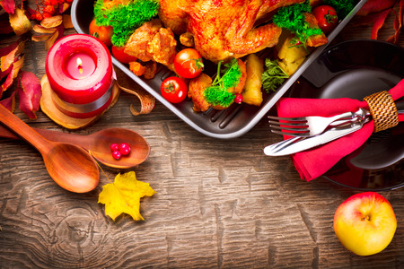 Thanksgiving items on wooden table - turkey, apple, leaves, candle