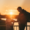 Father and daughter on the bridge at sunset. The concept of a happy family.