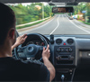 Man driving a car on the road. View from inside the car.