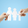 hands holding paper family on a blue background