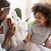  daughter play with father people sit on couch holding soft animals toys acting out fun performance