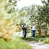 senior couple hiking with trekking sticks and backpacks