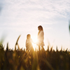 In beautiful sunlight. Majestic view. Two little girls have fun outdoors on the field at summer