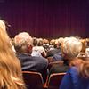 Audience in theathre waiting for drama play to start sen from the rear.