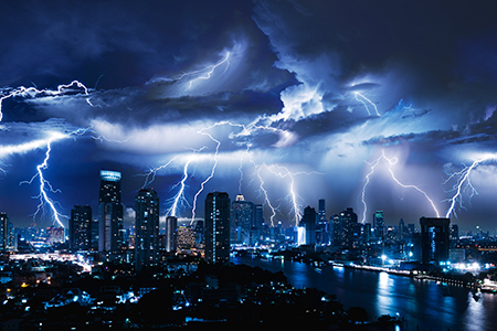 Lightning storm over city in blue light