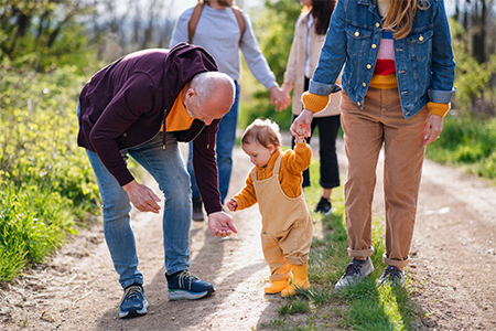 toddler with parents and grandparents on a walk outdoors