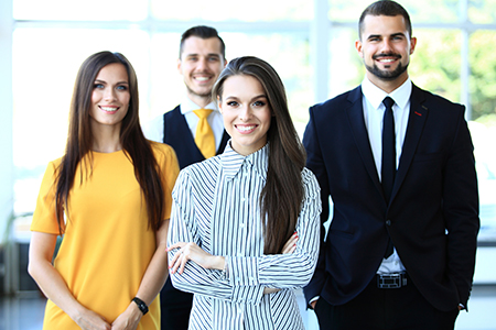 Happy business team with arms crossed at office